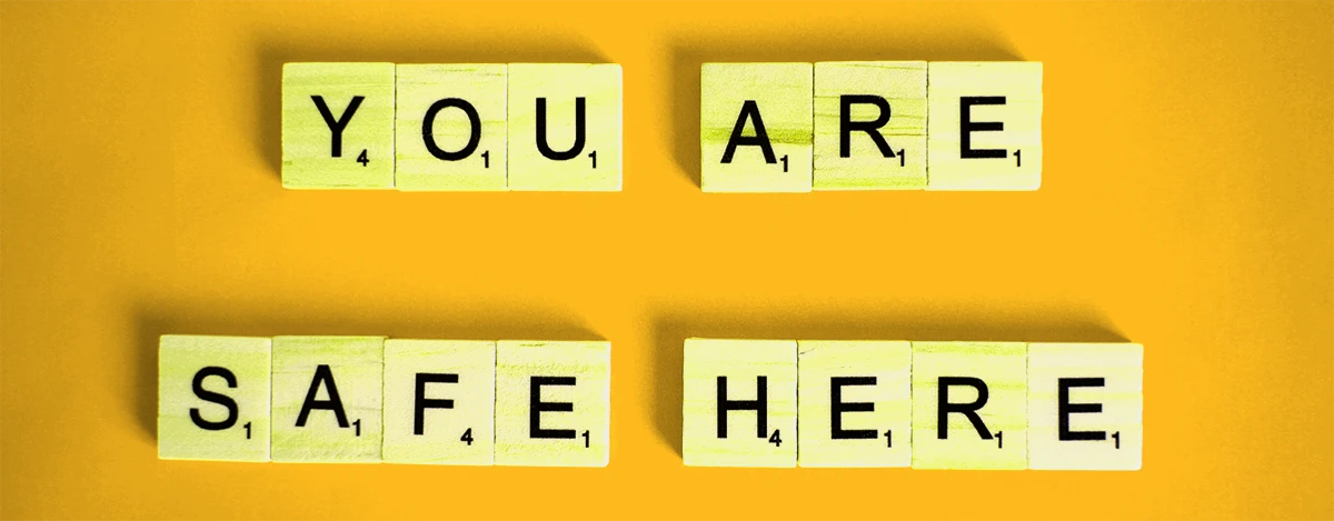 A few elements of the scrabble game creating the sentence "you are safe here".
